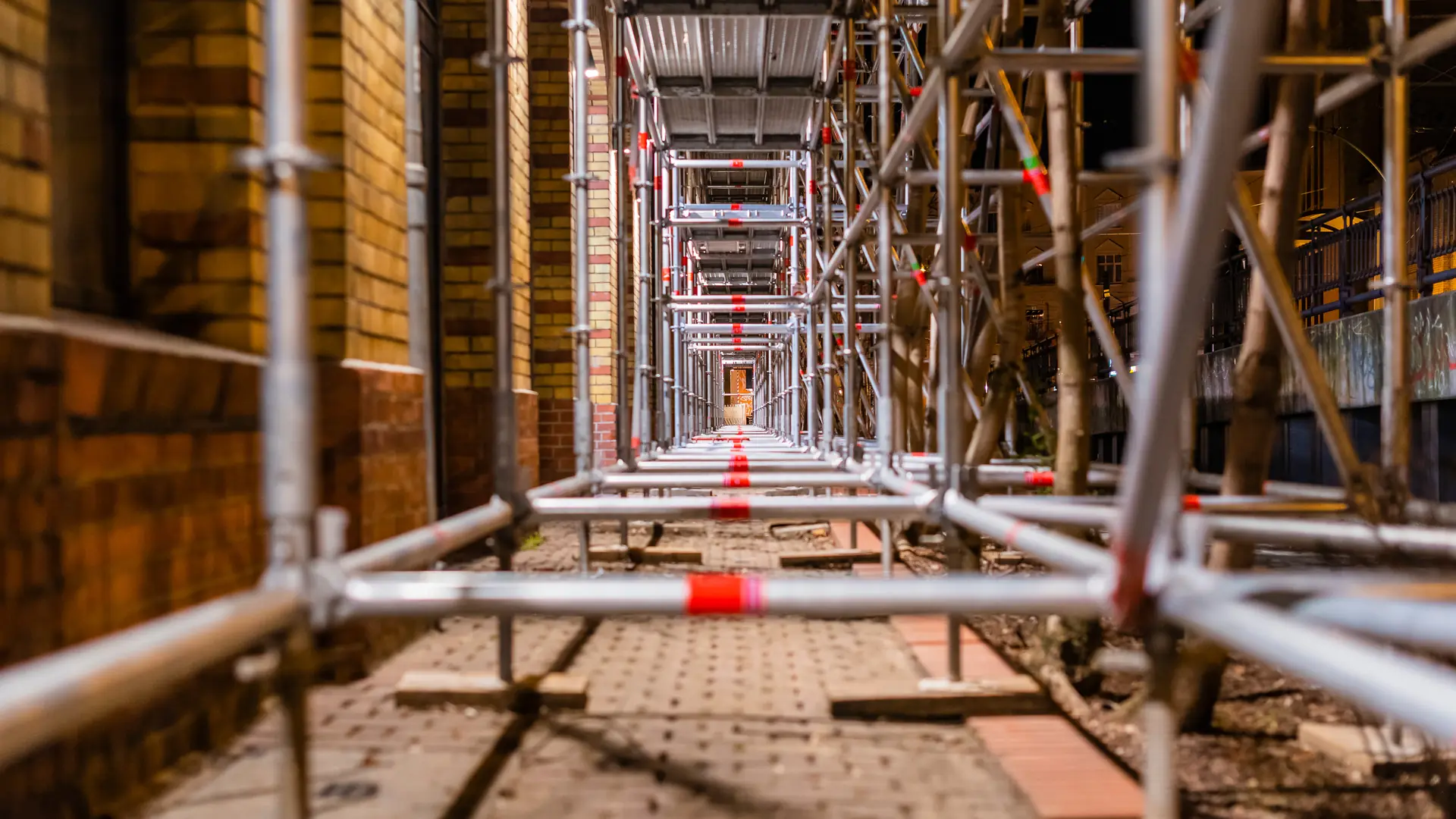Scaffold tube and fitting structure running alongside a building