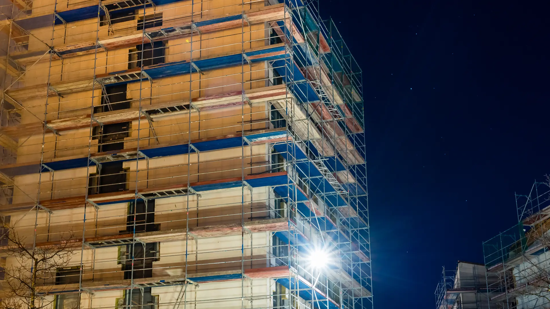 Scaffolding lit up at night on a multi-storey building