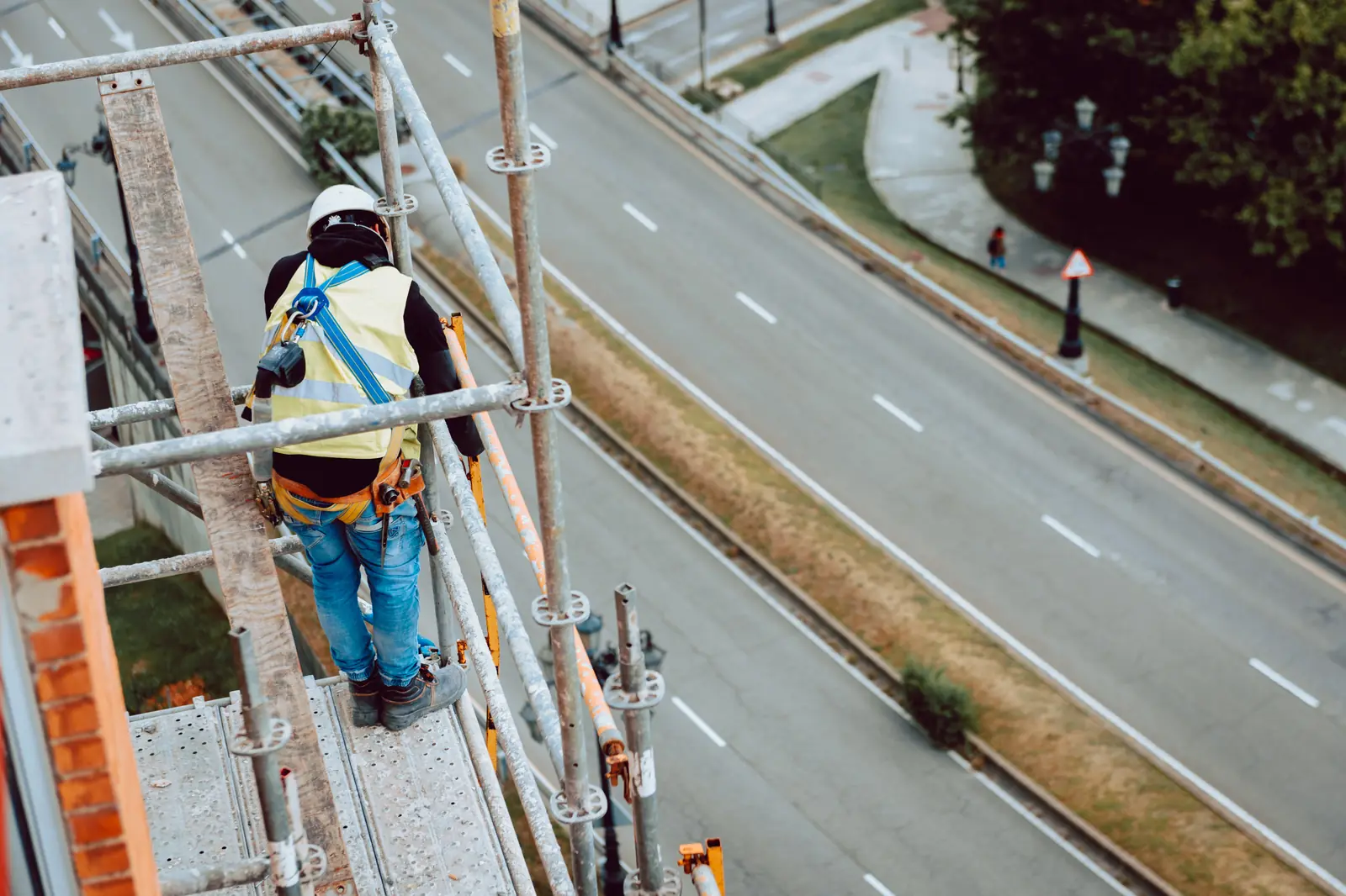 Scaffolder standing on a scaffold platform above a road