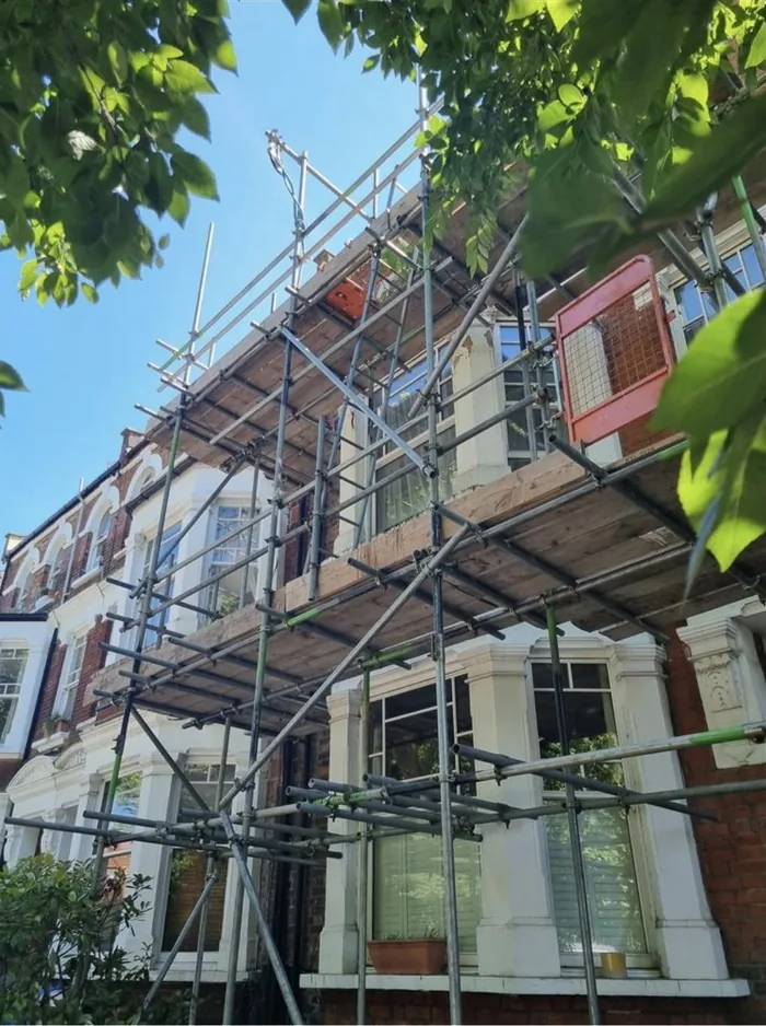 Two boarded working lifts on the front elevation of a Victorian terrace